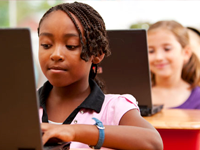 two students working on laptops 